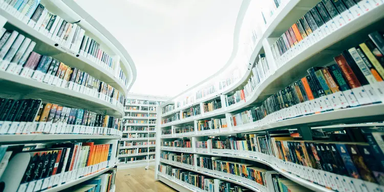 Vorsicht vor generischen Keywords 1 Gang in einer Bibliothek, weiße, geschwungene Regale, voll mit Büchern